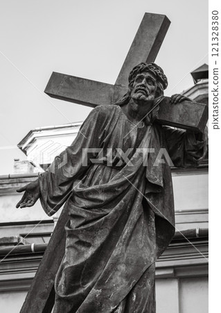 Sculpture of Jesus Christ with cross, black and white. Ancient monument of Jesus Christ in Lviv, Ukraine. Faith and sorrow concept. Old religious monument. Faith symbol and sign.  121328380