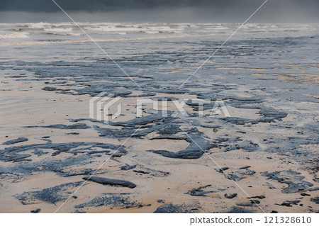 The ocean and the beach are polluted with oil. Beach oil spill impact, pollution, waste disposal. The ocean and the beach are polluted with oil. Beach oil spill impact, pollution, waste disposal. 121328610