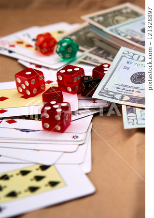 Poker deck spread out on a table with a pile of different dice and dollars. Poker deck spread out on a table with a pile of different dice and dollars. 121328897