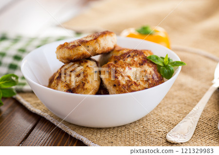 fried chicken cutlets in a bowl on a wooden table 121329983