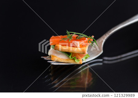 small snack canapes with crackers and lightly salted red fish Salmon, isolated on black background 121329989