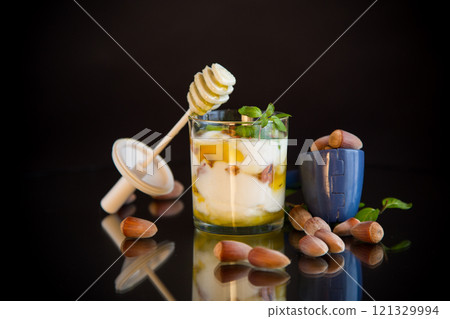 homemade yogurt with kiwi, honey and nuts in a glass, isolated on black background 121329994