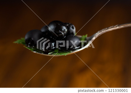 black olives in a spoon black olives in a spoon 121330001