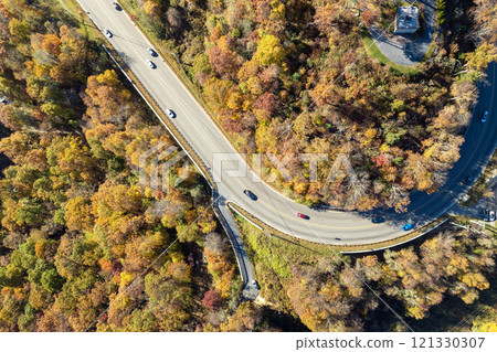 Freeway road with fast moving traffic cars and trucks in North Carolina Appalachian mountains in fall season. Interstate transportation infrastructure in USA Freeway road with fast moving traffic cars and trucks in North Carolina Appalachian mountains in fall season. Interstate transportation infrastructure in USA 121330307
