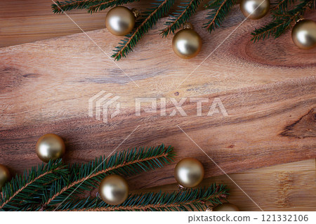 New Year's background made of wood with a Christmas tree branch and framed by New Year's baubles. New Year's background made of wood with a Christmas tree branch and framed by New Year's baubles. 121332106