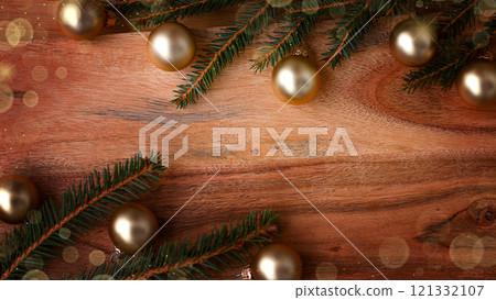 New Year's background made of wood with a Christmas tree branch and framed by New Year's baubles. New Year's background made of wood with a Christmas tree branch and framed by New Year's baubles. 121332107