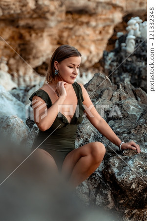 Woman Rocks Beach - Woman sitting on rocks by the sea in a swimsuit. Woman Rocks Beach - Woman sitting on rocks by the sea in a swimsuit. 121332348