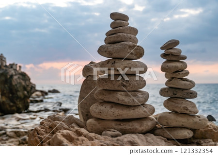 Stone Cairns Beach Sunset - Two rock towers on a beach at sunset. 121332354