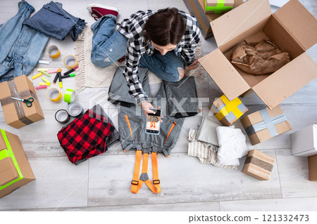 Girl Takes Photos Of Pre-Owned Clothes To Sell Online, Focusing On Selling Second-Hand Items Girl Takes Photos Of Pre-Owned Clothes To Sell Online, Focusing On Selling Second-Hand Items 121332473