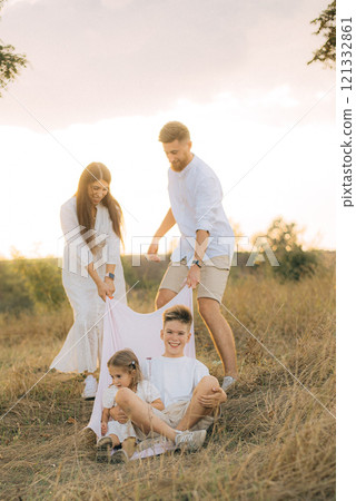 Happy young family with two children having fun in park on a sunny day Happy young family with two children having fun in park on a sunny day 121332861