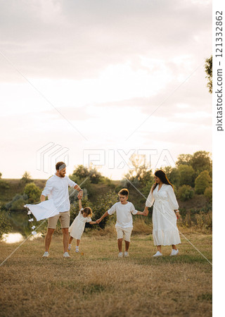 Happy young family with two children having fun in park on a sunny day Happy young family with two children having fun in park on a sunny day 121332862