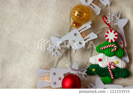 Christmas decorations, a toy Christmas tree on a beige knitted background 121333555
