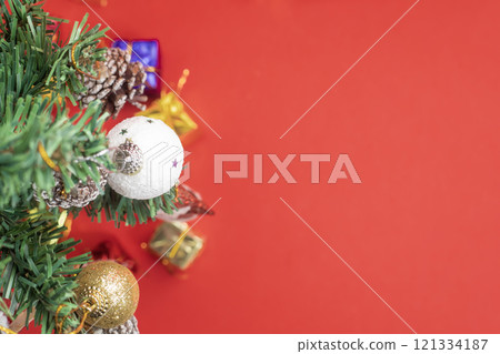 Decorated Christmas tree and colorful gift boxes on a red background with copy space, Top view 121334187