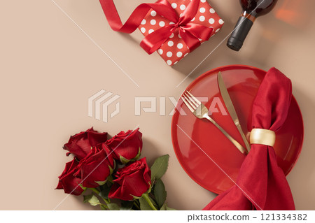 Valentine's day. Romantic dinner for date with red plate, chocolate sweets, romantic gift, wine and red roses on beige background. View from above. Copy space. 121334382