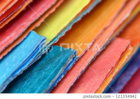 Detailed closeup showcasing the vivid colors and textures of the edges of open book pages, highlighting a lively interaction with printed words 121334942