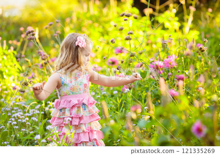 Little girl in flower garden Little girl in flower garden 121335269