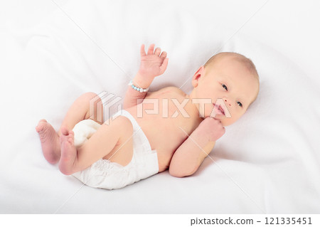 Little baby on white bed 121335451