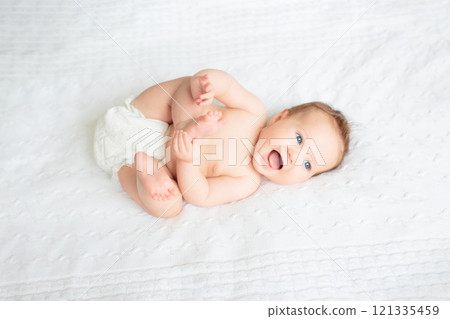 Little baby on white bed 121335459
