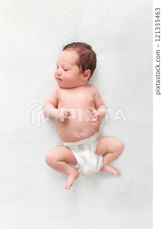 Little baby on white bed 121335463