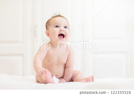 Little baby on white bed 121335528