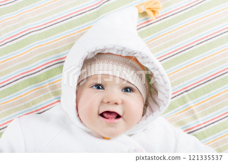 Little baby in winter hat on white bed 121335537