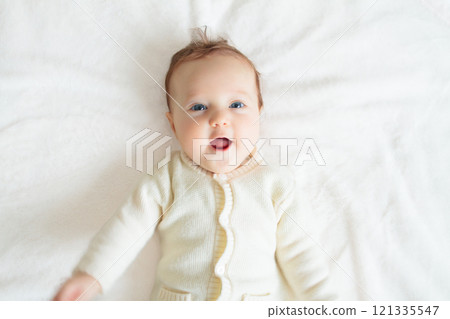 Little baby on white bed 121335547
