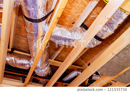 Metal ductwork, beams are exposed in ceiling, during ongoing renovation in residential space. 121335730