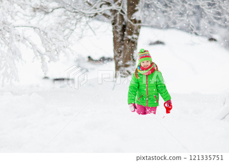 Girl on sled ride. Child sledding. Kid on sledge 121335751