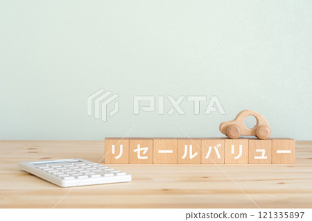 一個寫有轉售價值的積木、一個計算器和一個汽車模型。 一個寫有轉售價值的積木、一個計算器和一個汽車模型。 121335897