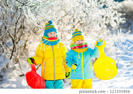 Kids play in snow. Winter sled ride for children Kids play in snow. Winter sled ride for children 121335956