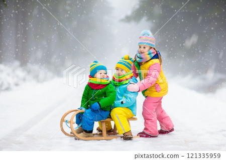 Kids play in snow in winter park 121335959