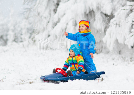 Kids play in snow in winter park Kids play in snow in winter park 121335989