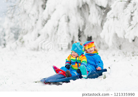 Kids play in snow in winter park 121335990