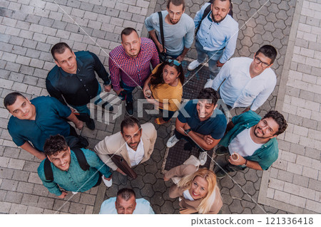 A top view photo of group of businessmen and colleagues standing together, looking towards the camera, symbolizing unity and teamwork. A top view photo of group of businessmen and colleagues standing together, looking towards the camera, symbolizing unity and teamwork. 121336418