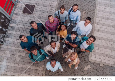 A top view photo of group of businessmen and colleagues standing together, looking towards the camera, symbolizing unity and teamwork. 121336420