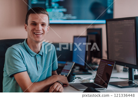 A programmer diligently testing smartphone applications while sitting in their office. 121336448