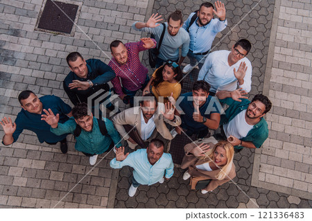 A top view photo of group of businessmen and colleagues standing together, looking towards the camera, symbolizing unity and teamwork. 121336483