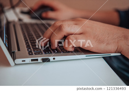 Close-up photo of a programmer typing on a laptop 121336493