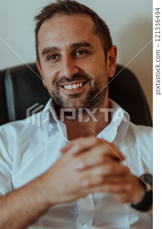 A successful businessman is sitting in his office after a hard day's work A successful businessman is sitting in his office after a hard day's work 121336494