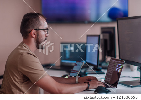 A programmer diligently testing smartphone applications while sitting in their office. 121336553