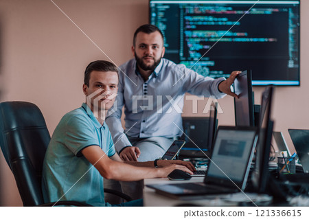 Programmers engrossed in deep collaboration, diligently working together to solve complex problems and develop innovative mobile applications with seamless functionality. 121336615