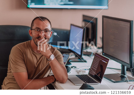 A programmer diligently testing smartphone applications while sitting in their office. 121336659