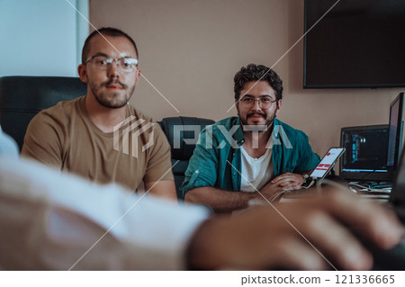 Programmers engrossed in deep collaboration, diligently working together to solve complex problems and develop innovative mobile applications with seamless functionality. 121336665