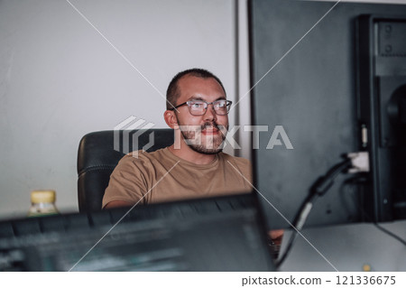 A programmer diligently testing smartphone applications while sitting in their office. 121336675