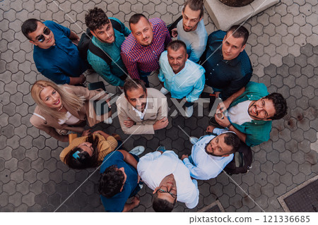 A top view photo of group of businessmen and colleagues standing together, looking towards the camera, symbolizing unity and teamwork. 121336685