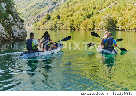 A group of friends enjoying having fun and kayaking while exploring the calm river, surrounding forest and large natural river canyons 121336813