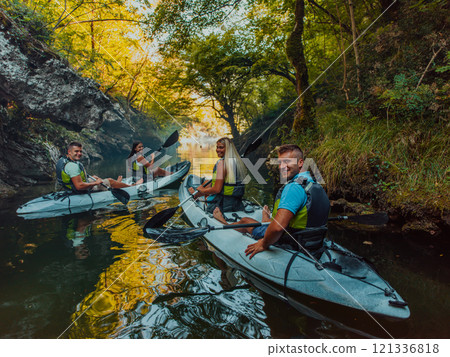 A group of friends enjoying having fun and kayaking while exploring the calm river, surrounding forest and large natural river canyons 121336818