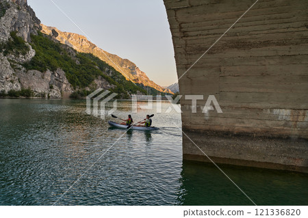A group of friends enjoying having fun and kayaking while exploring the calm river, surrounding forest and large natural river canyons 121336820
