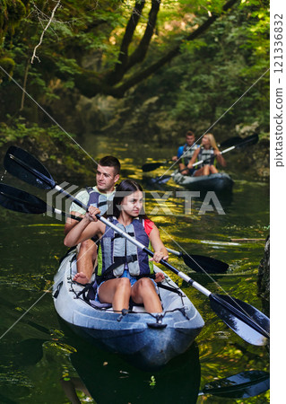 A group of friends enjoying having fun and kayaking while exploring the calm river, surrounding forest and large natural river canyons 121336832