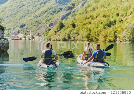 A group of friends enjoying having fun and kayaking while exploring the calm river, surrounding forest and large natural river canyons 121336930